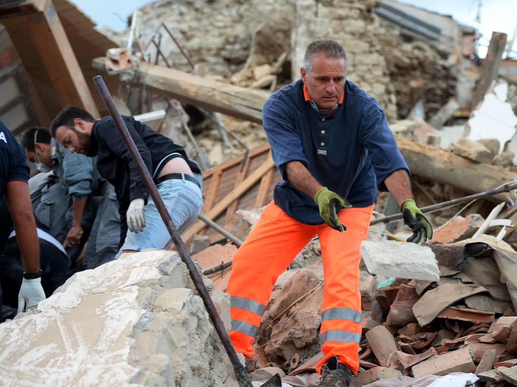 Rescuers clear debris while searching for victims in damaged buildings after a strong earthquake hit Amatrice on August 24, 2016. Picture: AFP