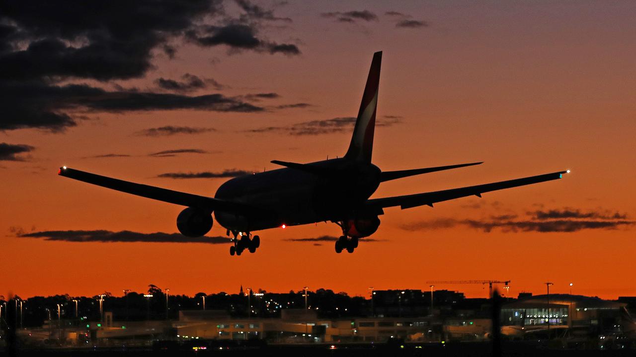 Sydney Airport resembles a ghost town as Sydney enters its 8th week of lockdown due to the Covid-19 pandemic. A Qantas plane lands on the east west runway at sunset. Picture: Toby Zerna