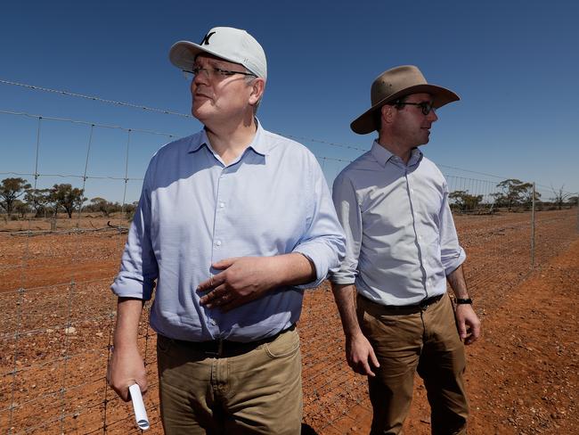 Prime Minister Scott Morrison (left) and Minister for Agriculture and Water Resources David Littleproud inspect a dog-proof fence during a regional tour in Quilpie in southwest Queensland on Monday. Picture: Alex Ellinghausen/AAP