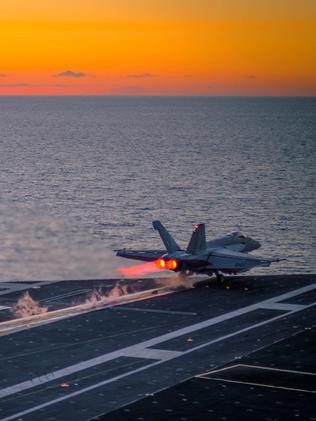 An F/A-18E Super Hornet launches at sunset from the flight deck of the aircraft carrier USS Ronald Reagan. The survivability of such aircraft in high-intensity warfare is in doubt. Picture: US Navy