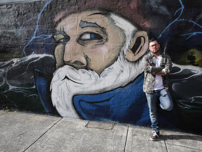 Visual artist Joe Quilter in front of one of his murals in Newtown. Picture: Craig Wilson