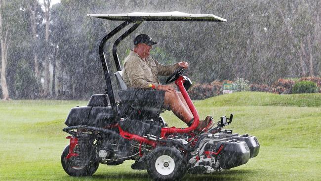 Half Moon Bay Golf Club course superintendent Grant Cockerell puts the mower away as the rain buckets down. PICTURE: BRENDAN RADKE.