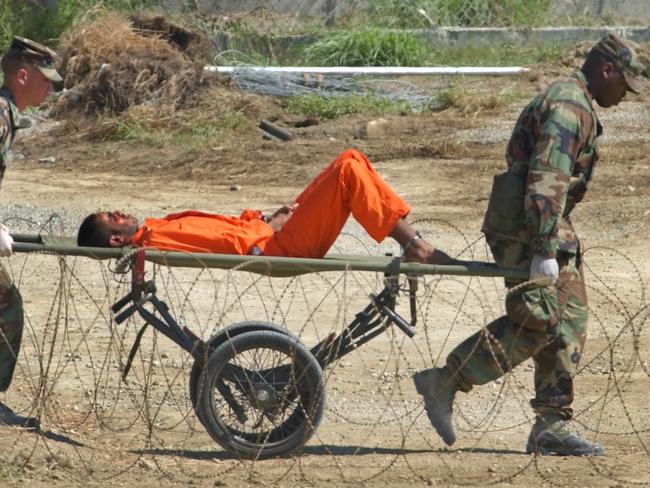 A detainee is carried on a stretcher before being interrogated.