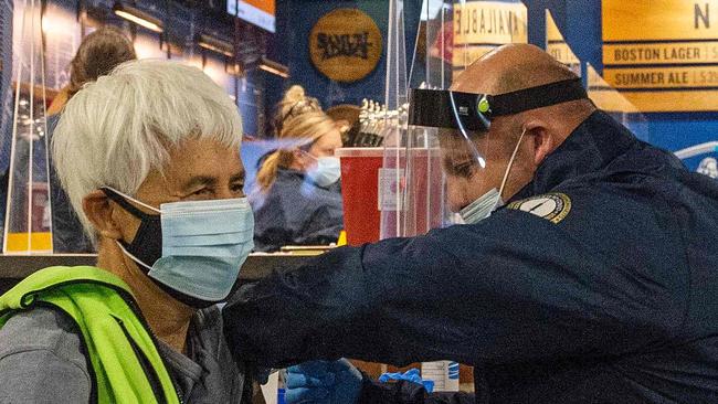 A staff worker delivers a dose of Covid-19 vaccine to a patient at Fenway Park in Boston, Massachusetts. Picture: AFP