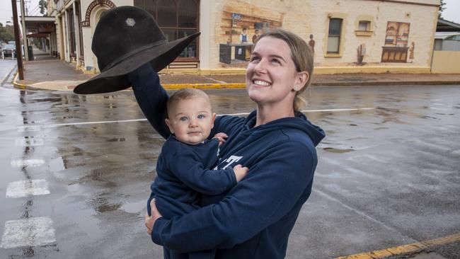 Peterborough primary school teacher Ayla Conway holds her baby boy Jasper as he sees rain for the first time. Picture: Mark Brake