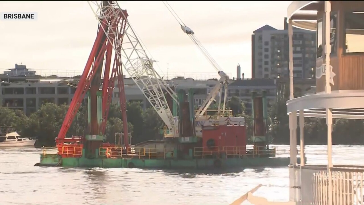 Crane on loose pontoon threatens to fall into Brisbane River