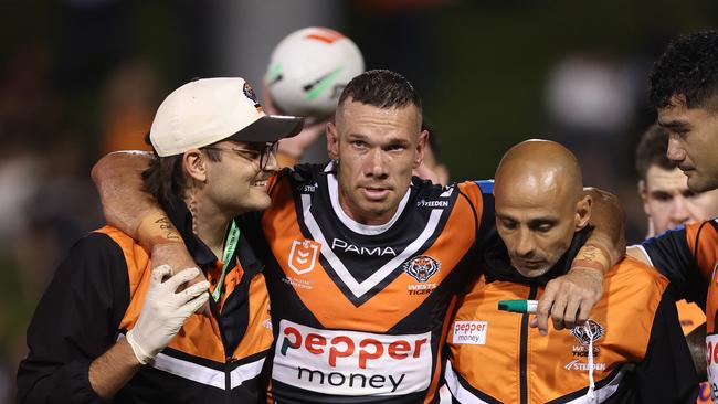 SYDNEY, AUSTRALIA - FEBRUARY 21:  Brent Naden of the Wests Tigers is assisted off the field after a knee injury during the 2025 NRL Pre-Season Challenge match between Wests Tigers and Parramatta Eels at Leichhardt Oval on February 21, 2025 in Sydney, Australia. (Photo by Mark Metcalfe/Getty Images)