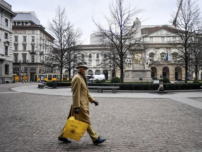 A man walks through an empty Piazza in Milan. Italy has ordered all restaurants, cafes and shops to close in a nationwide lockdown. Picture: Claudio Furlan/LaPresse via AP.
