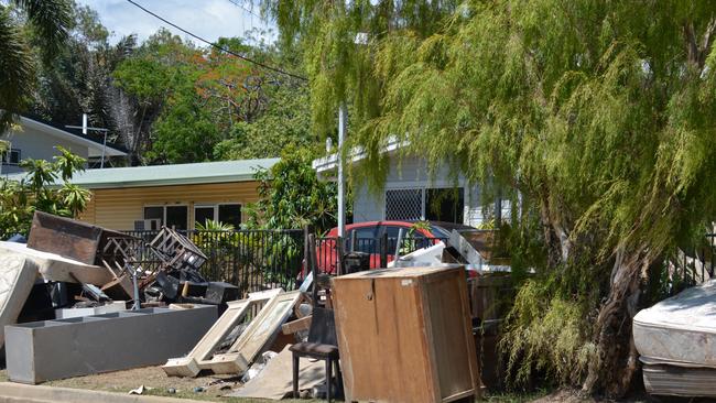 Streets in Machans Beach are piled high with wrecked furniture, whitegoods, mattresses and household contents as residents sort through what little is left. Picture: Bronwyn Farr