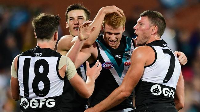 Willem Drew celebrates the first goal of his AFL career in Round 4 with teammate Zak Butters, Connor Rozee and Brad Ebert. Picture: Mark Brake/Getty