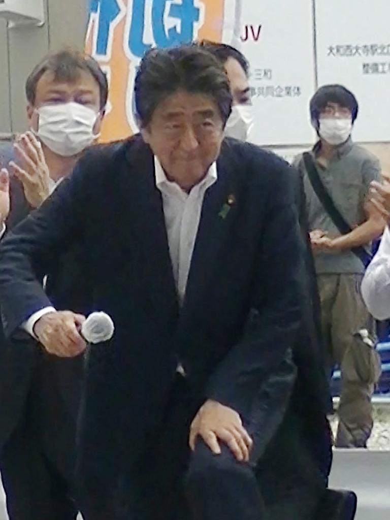 Mr Abe is pictured moments before he was shot as the alleged shooter lurks behind him in a grey shirt. Picture: AFP/Toshiharu Otani via Jiji Press