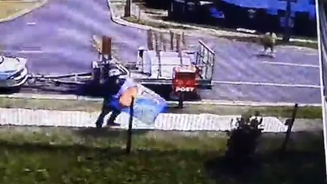 A man helping Allan de Brenni removes a Darren Power sign from a fence in Ewing Rd, Woodridge.