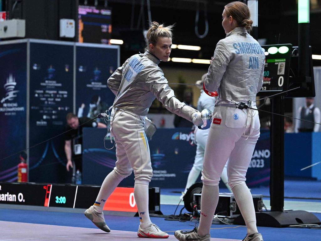 Ukraine's Olga Kharlan (L) gestures towards Russia's Anna Smirnova, registered as an Individual Neutral Athlete (AIN), prior to competing during the Sabre Women's Senior Individual qualifiers, as part of the FIE Fencing World Championships at the Fair Allianz MI.CO (Milano Convegni) in Milan, on July 27, 2023. (Photo by Andreas SOLARO / AFP)