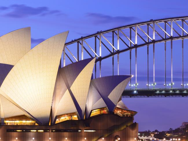 Sydney, Australia - November, 21st 2012; Sydney Opera House and the Harbour Bridge illuminated at dusk. View across Farm Cove, looking west.