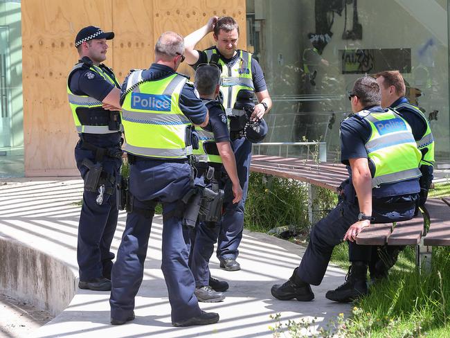 Police monitor the area during the clean-up. Picture: Ian Currie