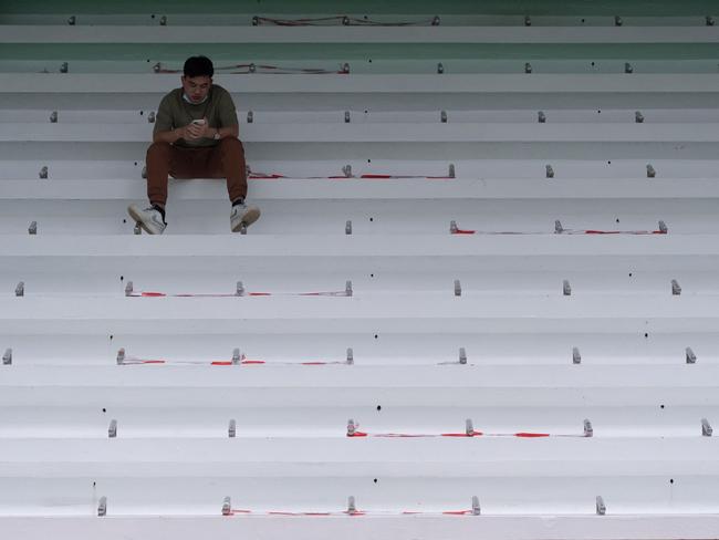 A man uses his phone on seating with social distancing markers amid the Covid-19 pandemic at a playground in Hong Kong. Picture: AFP