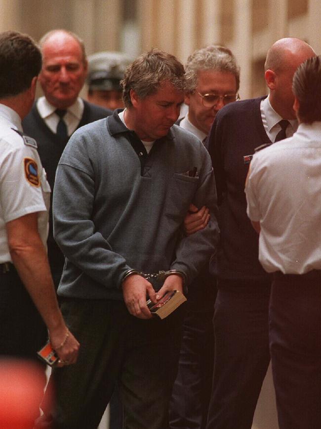 Coulston is led handcuffed into the Supreme Court to be sentenced for the murders of Peter Dempsey, Kerryn Henstridge and Anne Smerdon.