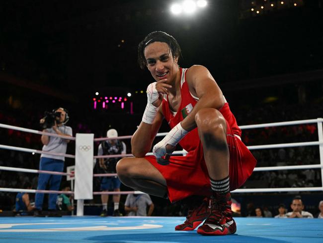 TOPSHOT - Algeria's Imane Khelif reacts after beating China's Yang Liu (Blue) in the women's 66kg final boxing match during the Paris 2024 Olympic Games at the Roland-Garros Stadium, in Paris on August 9, 2024. (Photo by MOHD RASFAN / AFP)