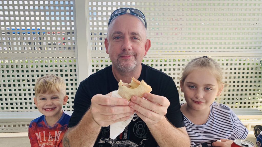 Richard Roberts with son Riley Roberts, 5, and daughter Abby Roberts, 8, enjoying the sausage sizzle. Picture: Rainee Shepperson