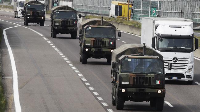 Military trucks moving coffins of deceased people line up on the highway next to Ponte Oglio, near Bergamo, one of Italy’s areas worst hit by the coronavirus infection. A new study quantifying the hidden toll from coronavirus in the province of Bergamo has found that the number of deaths linked to the virus is double the official tally. Picture: Luca Bruno/AP