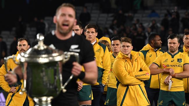 All Blacks captain Keiran Read with the Bledisloe Cup as Wallabies players look on. Picture: AAP