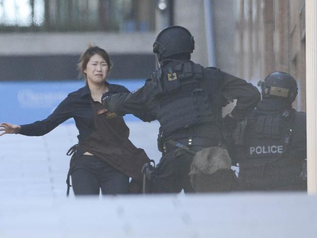 Terror... Hostage runs to police during Lindt siege. Photos: Chris McKeen