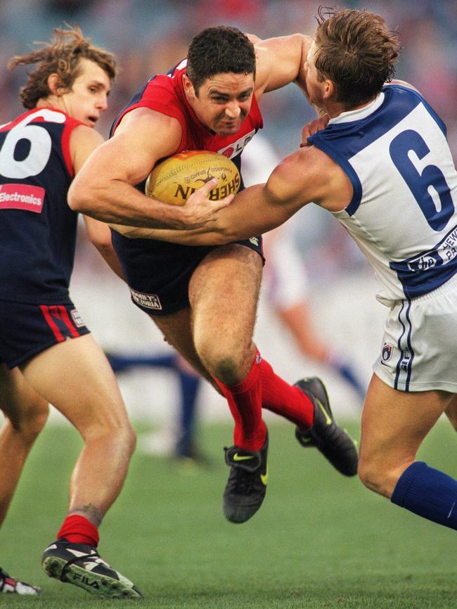 Garry Lyon bursts through a Shannon Grant tackle in 1998.