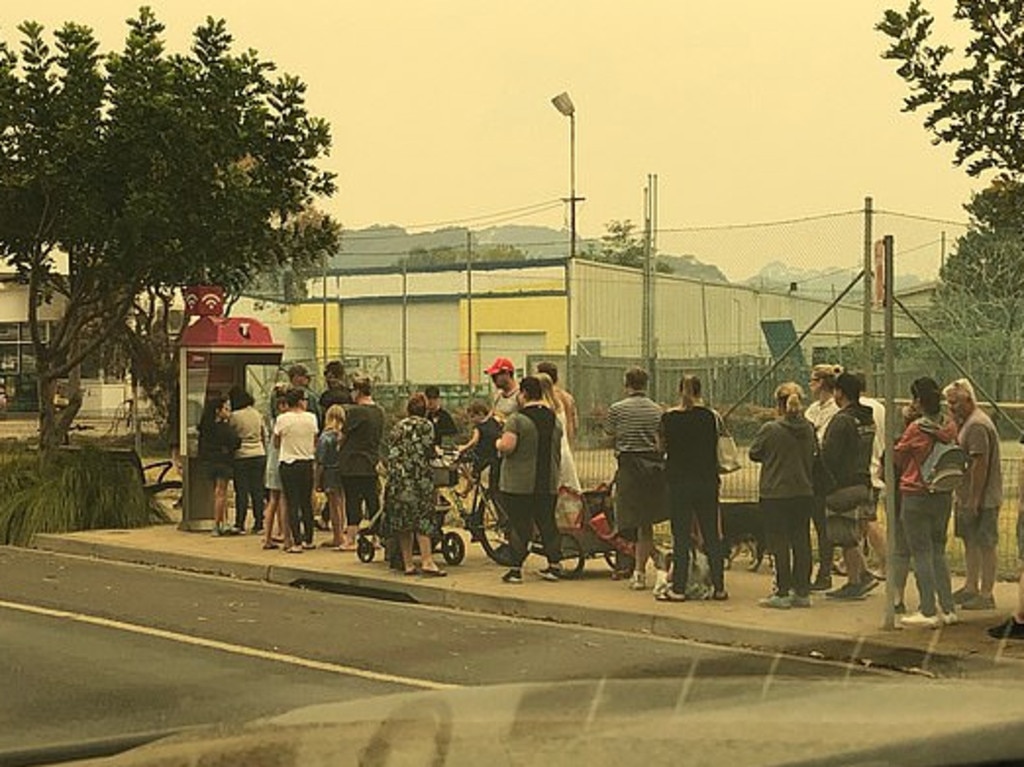 People lining up to use a public telephone booth after telephone reception was cut across the south coast of NSW.