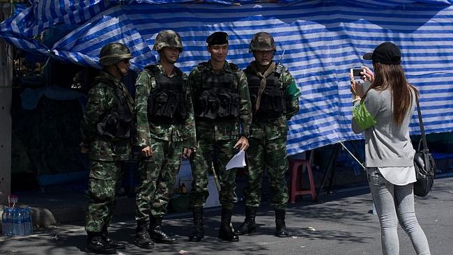 Thai soldiers pose for a photo as they check an area near government house in Bangkok. Picture: AFP