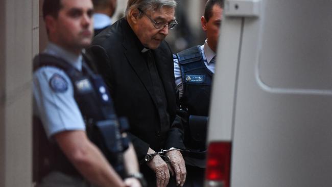 Cardinal George Pell is led to a prison van in handcuffs. Picture: AAP Image/Erik Anderson