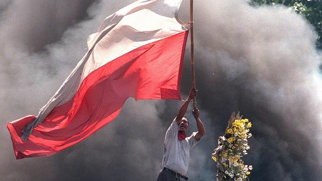 An demonstrator holds a huge Indonesian flag in fire and smoke to rally his colleagues during violent clashes in May 1998. Picture: AFP