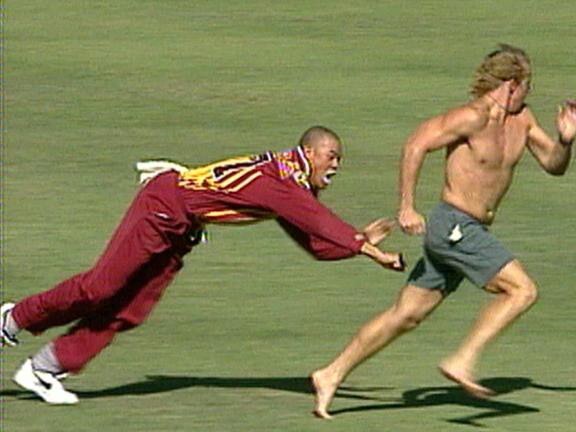 Andrew Symonds lunges at a pitch invader after he escaped his grasp in a Mercantile Mutual Cup game. Picture: Fox Sports.