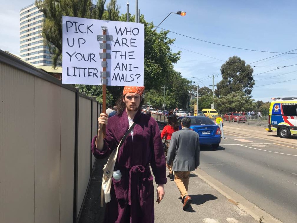 A protester outside the Melbourne Cup protests horse cruelty as well as littering.