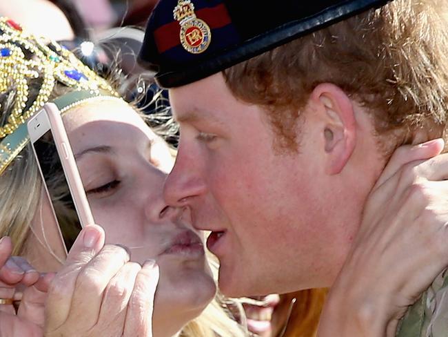 SYDNEY, AUSTRALIA - MAY 07: Prince Harry gets kissed by Royal Fan Victoria Mcrae during a walkabout outside the Sydney Opera House on May 7, 2015 in Sydney, Australia. Prince Harry is visiting Sydney following a month-long deployment with the Australian Army. (Photo by Chris Jackson/Getty Images)