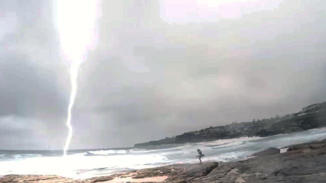 Fake video shows lightning almost hitting girl in Sydney. Filmed at Tamarama beach near Bondi in February 2016. Picture: YouTube.