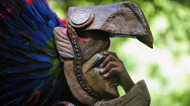 A member of a folk group performs wearing a Maya mask in Tikal archaeological site in Peten departament 560 km north of Guatemala city on December 20, 2012. Ceremonies will be held here to celebrate the end of the Mayan cycle known as Bak'tun 13 and the start of the new Maya Era on December 21. AFP PHOTO/Hector RETAMAL