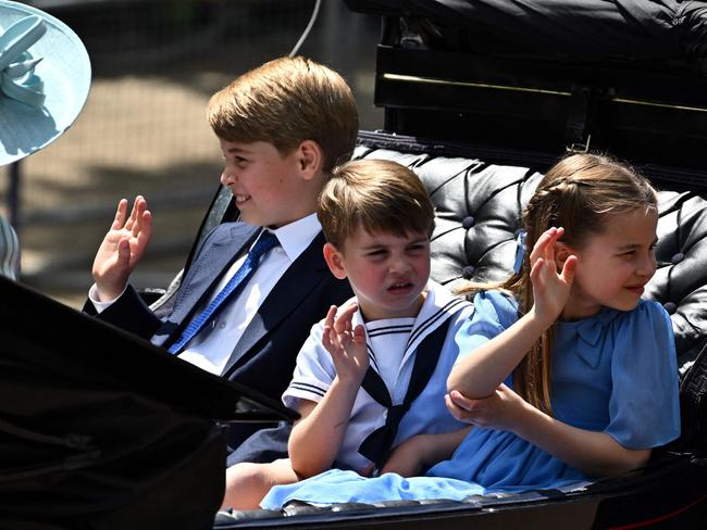 The three waved and smiled to the crowds lining the Mall near Buckingham Palace. Picture: AFP