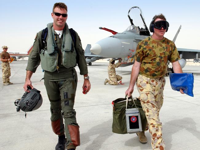 1JPAU14FEB03WG13 Caption: (L to R) A Royal Australian Air Force pilot and ground crew member walk the  F/A-18 Hornet flightline after arrival in the Middle East.   The F/A-18 Hornet is operated by No. 75 Squadron out of Tindal, Northern Territory.    The aircraft is Australia's frontline fighter, capable of air interception and ground force support.       The most recent operational deployment of RAAF F/A-18's was to Diego Garcia during Operation Slipper in 2001/02.  The arrival of the aircraft in the Middle East marks the largest operational fighter deployment since Korea in the early 1950's.