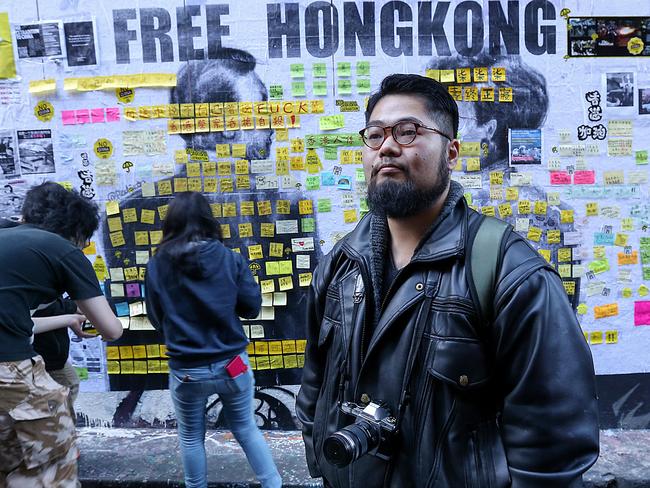 Dissident Chinese artist Badiucao in front of his artwork, Melbourne. He says he cannot set foot in Hong Kong without fear of being arrested under the new law. Picture: Ian Currie