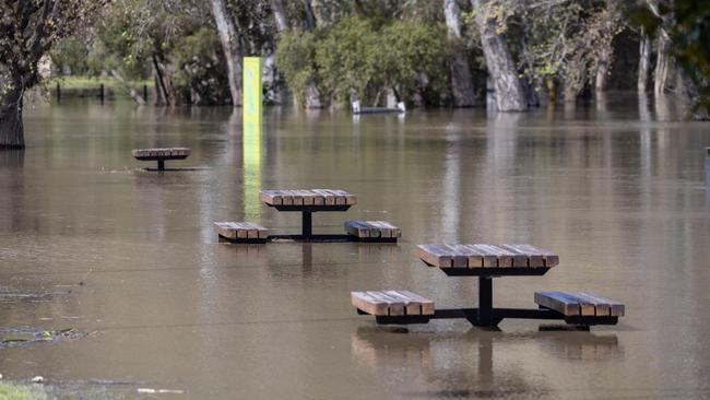 Bystanders watch the flooding along the shores of the Port of Sale. Picture: Jason Edwards