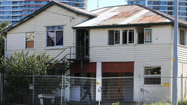 A man runs into the squatter house on Queen St, Southport. Picture Glenn Hampson