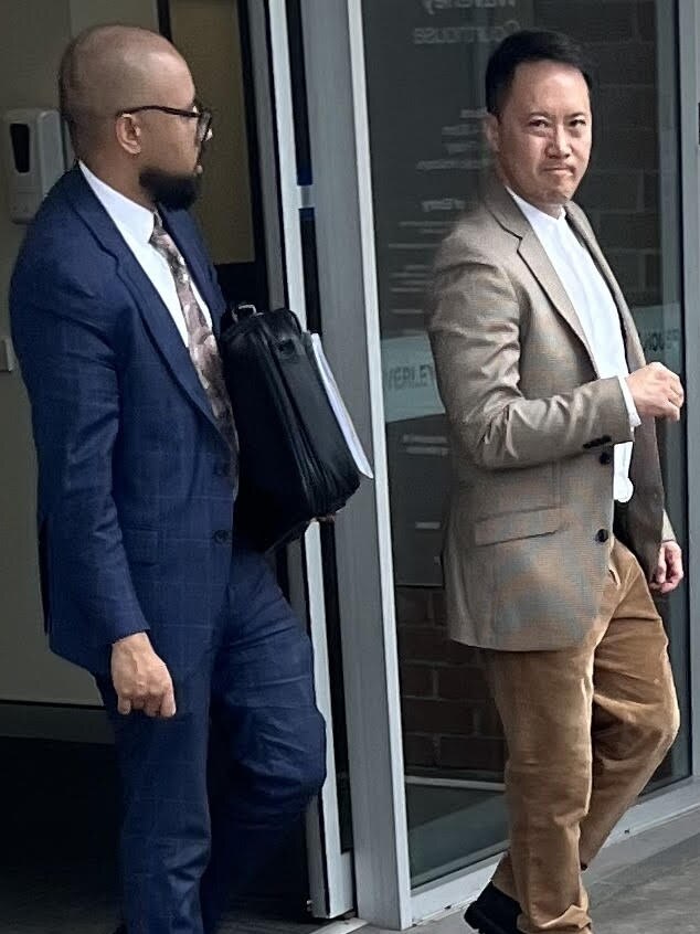 Feng (right) leaving court with his lawyer.