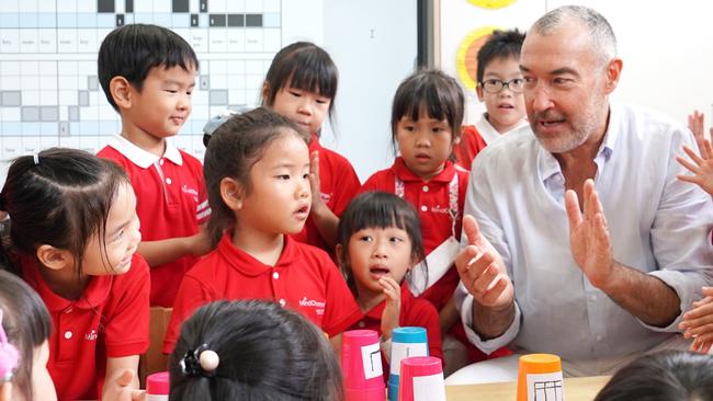 Former South Australian Lieutenant Governor Dr James Muecke with a MindChamps class in Singapore … he is on the MindChamps advisory board and is a strong supporter of its healthy eating program. Picture: Tessa Dempster