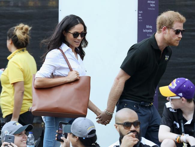 Prince Harry and Meghan Markle holding hands. Picture: Getty