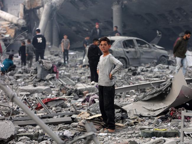 A young boy looks on as Palestinians stand amid the devastation in the yard of a school, a day after it was hit by an Israeli strike, in the al-Tuffah neighbourhood of Gaza City. Picture: AFP