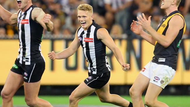 MELBOURNE, AUSTRALIA - APRIL 01: Taylor Adams and Adam Treloar of the Magpies celebrate winning as Jacob Townsend of the Tigers looks dejected after losing the round two AFL match between the Collingwood Magpies and the Richmond Tigers at the Melbourne Cricket Ground on April 1, 2016 in Melbourne, Australia. (Photo by Quinn Rooney/Getty Images)