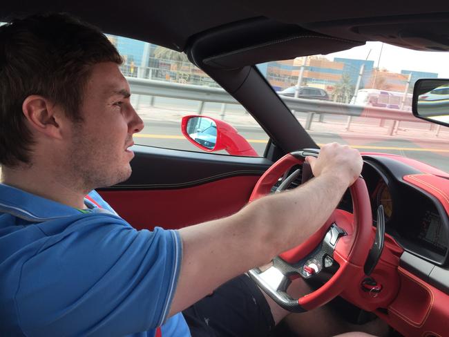 Adam Cranston behind the wheel of a Ferrari.