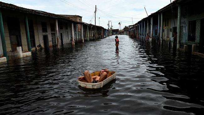 A man rides a handmade raft through a flooded street in Batabano, Mayabeque province, Cuba. Picture: AFP