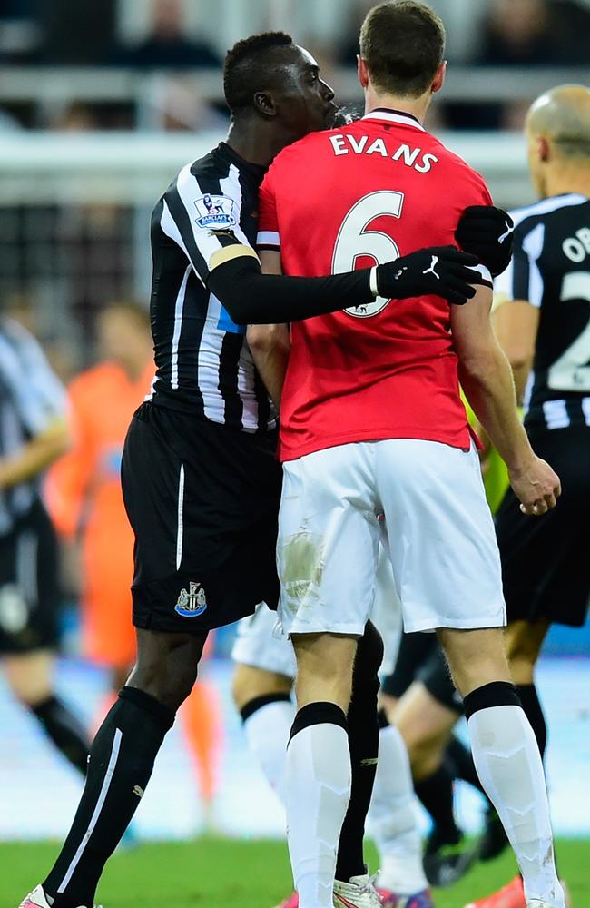 Jonny Evans (r) looks on as Papiss Cisse of Newcastle appears to spit.