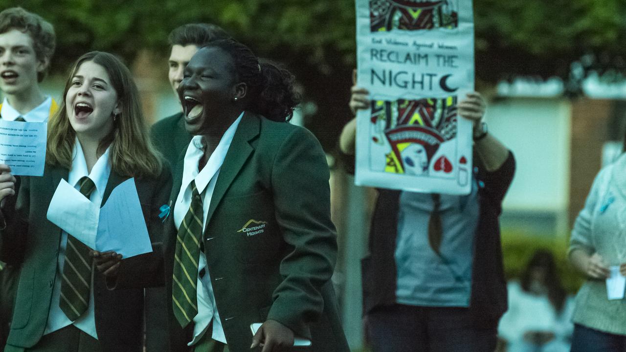 Centenary Heights SHS students Mia Jago (left) and Helen Jukudu join in the final chant as Reclaim the Night march arrives back at the village green, Friday, October 29, 2021. Picture: Kevin Farmer